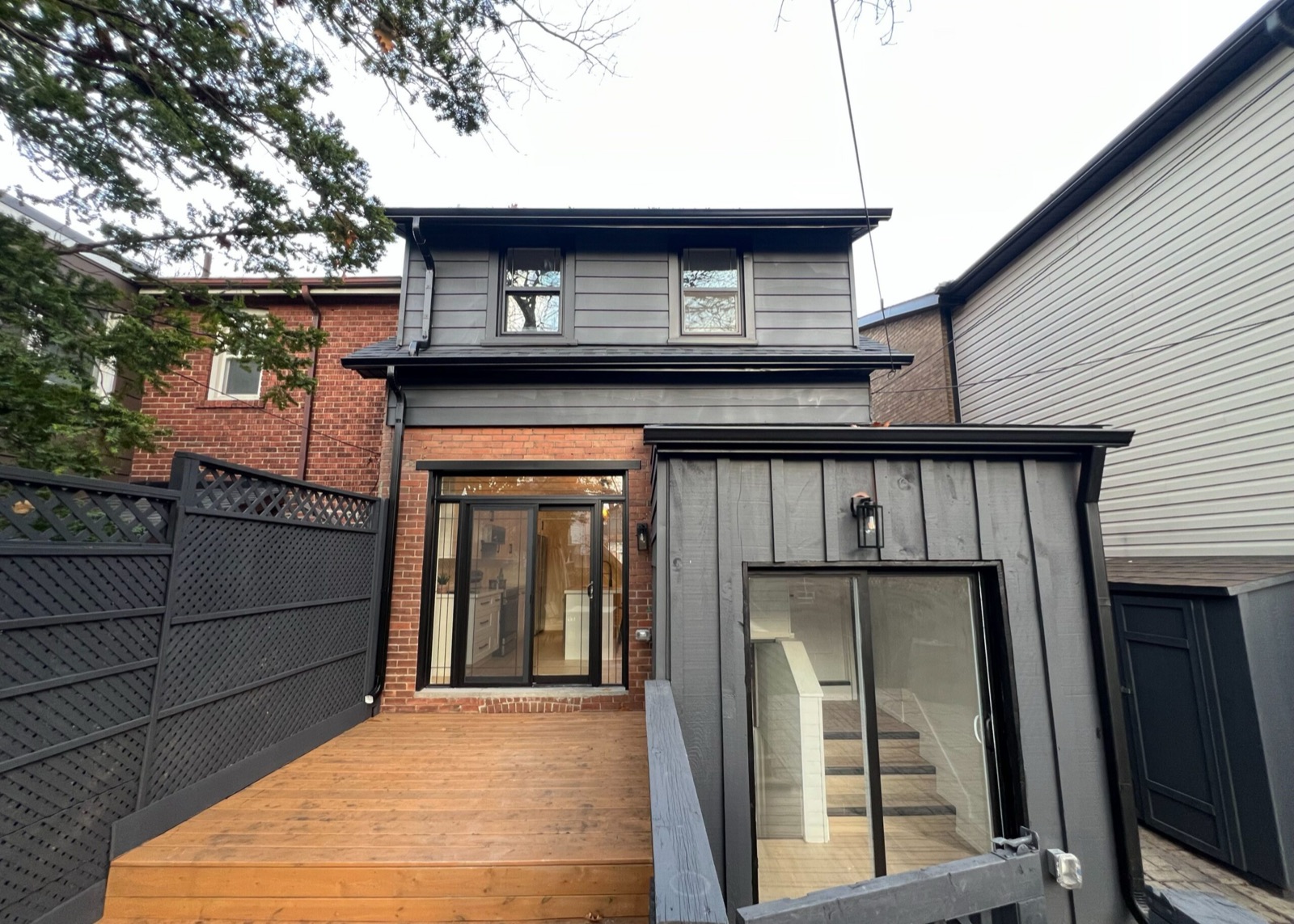 Rear of a house with a small enclosed entry and a glass door showing stairs inside