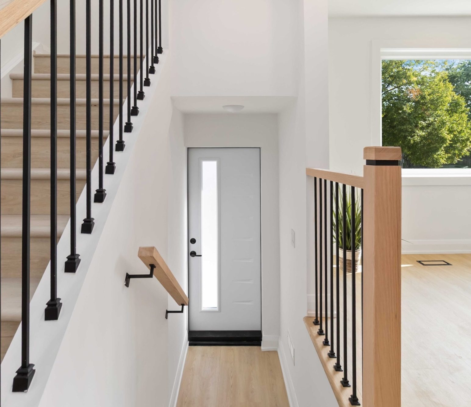 Side door at a stair landing with stairs going up on the left and a handrail going down