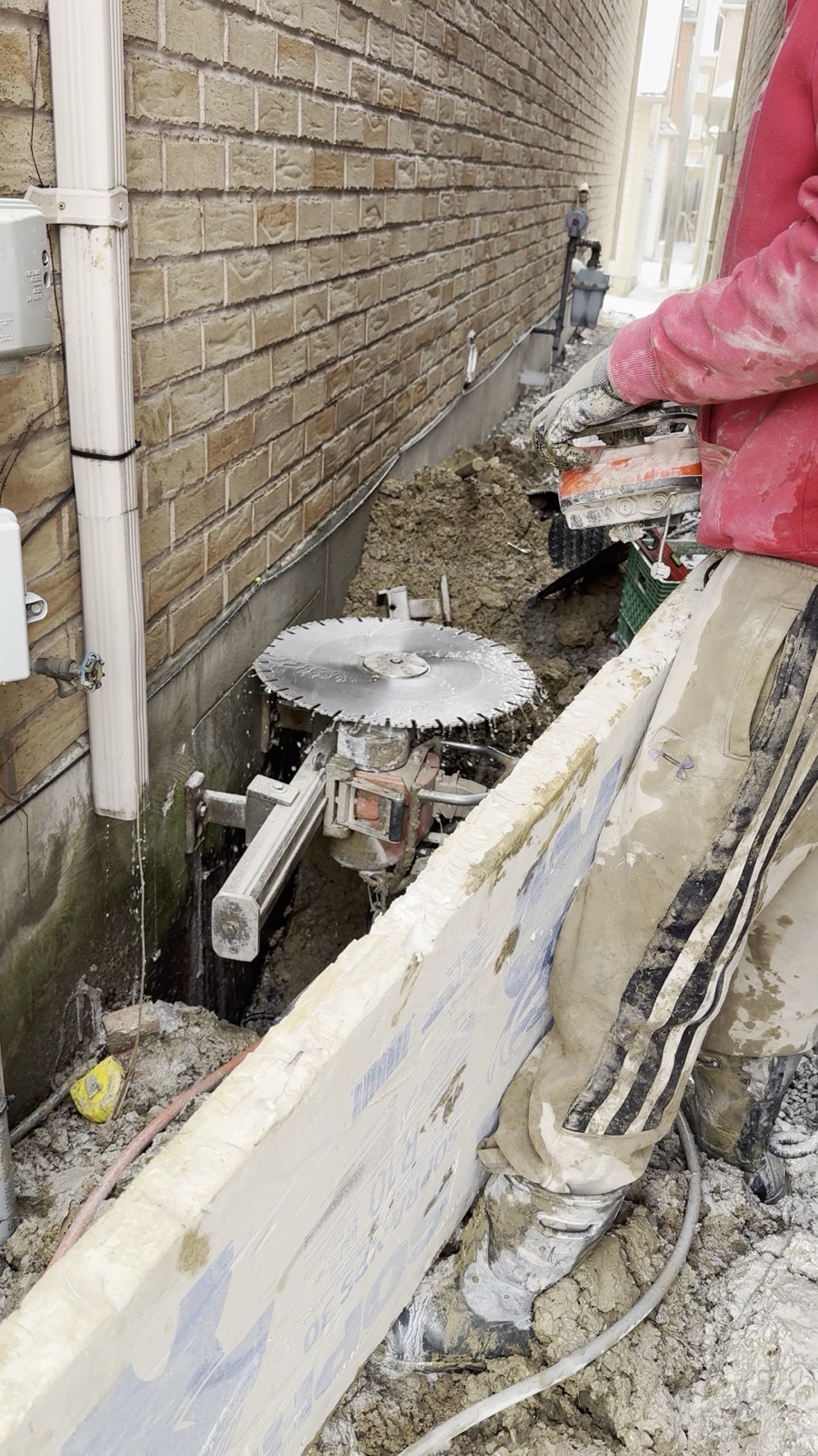 Concrete saw cutting a larger opening in a foundation wall