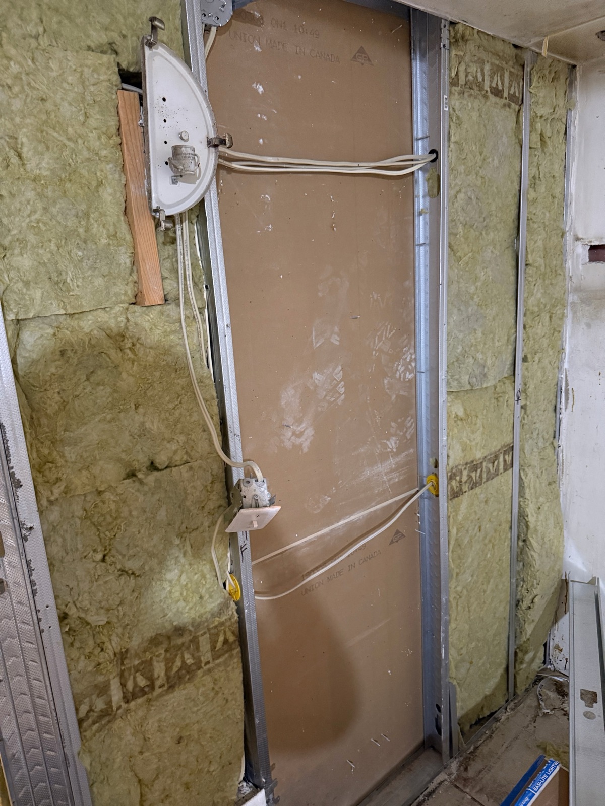 Stone wool insulation between steel studs next to a fire-rated drywall panel