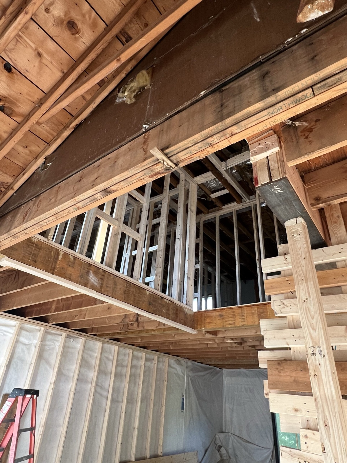 Built-up wood beams and new wall framing above an opening in an existing house