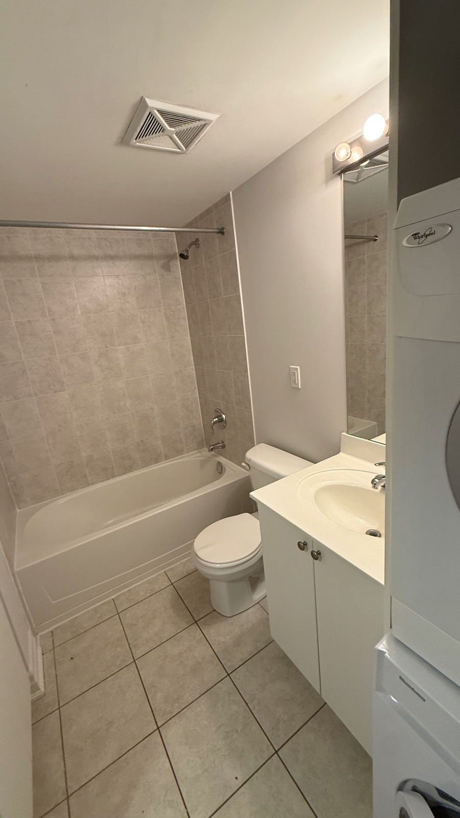 Small bathroom with a white alcove bathtub, tiled surround and shower curtain rod