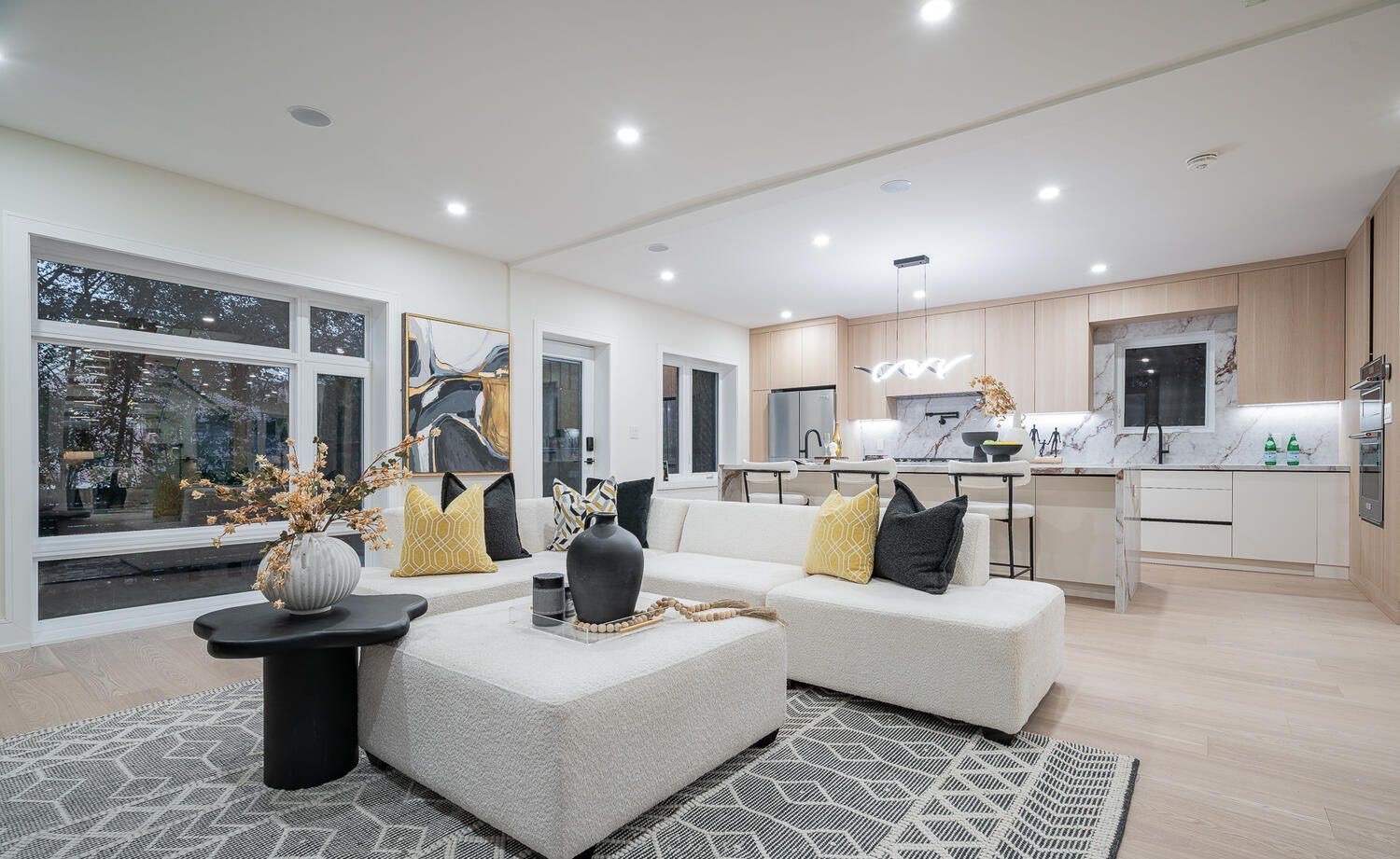 Open-plan living room and kitchen with light wide-plank flooring